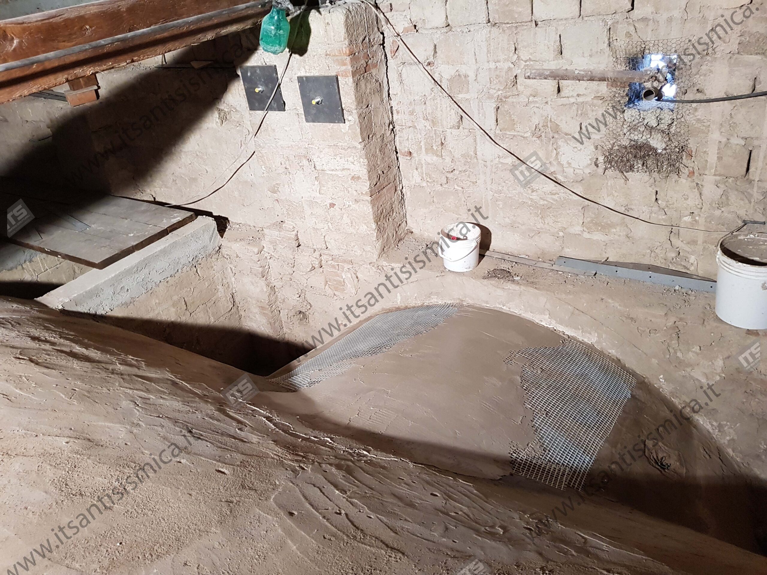 Posa della rete in fibra di vetro sull'estradosso di una volta, annegata nella malta fibrorinforzata